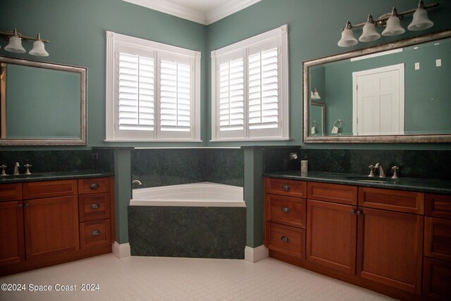 bathroom featuring a tub to relax in, vanity, and ornamental molding