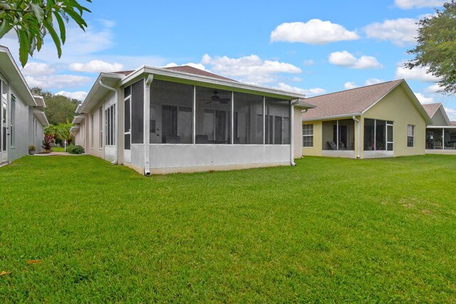 rear view of property with a lawn and a sunroom