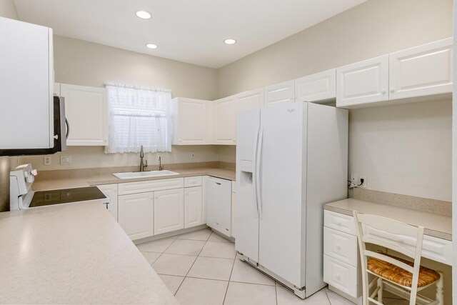 kitchen with white cabinets, sink, white appliances, and light tile patterned floors