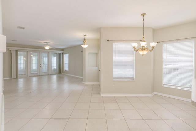 spare room with light tile patterned floors, ceiling fan with notable chandelier, and baseboards