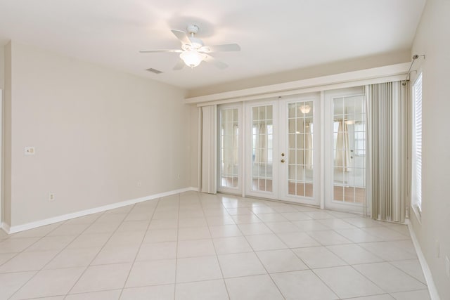 spare room with light tile patterned floors, baseboards, a ceiling fan, and french doors