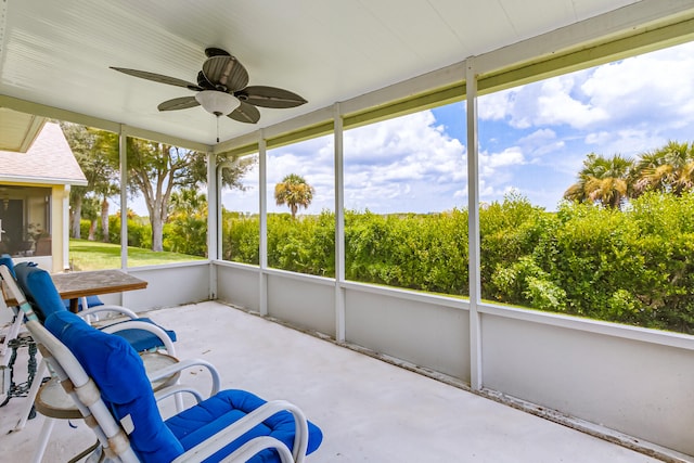 unfurnished sunroom featuring ceiling fan