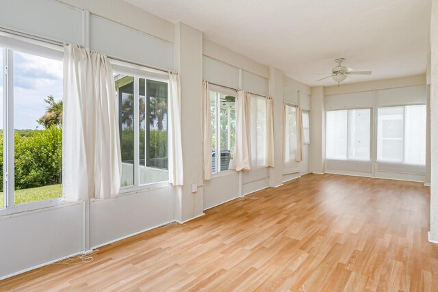 unfurnished sunroom with ceiling fan