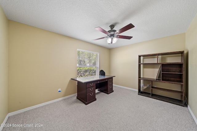 carpeted office with a textured ceiling and ceiling fan