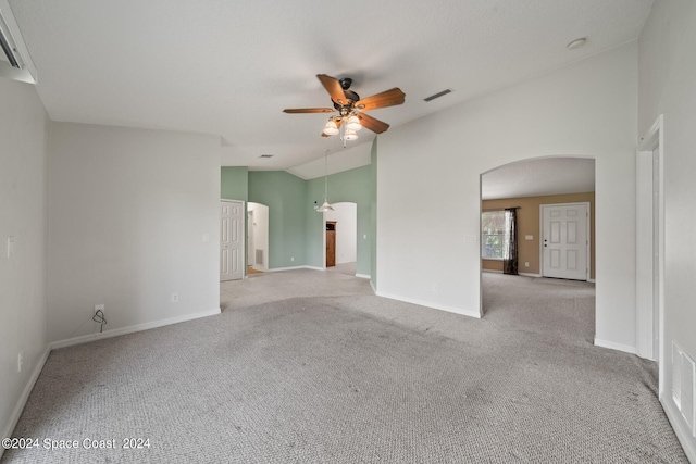 empty room featuring vaulted ceiling, light carpet, and ceiling fan