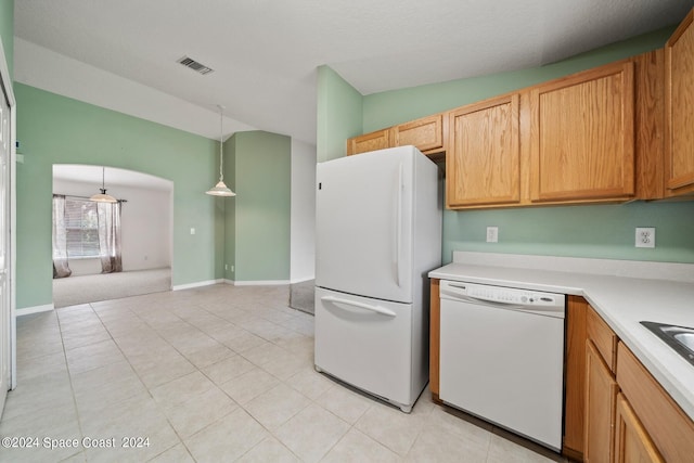 kitchen featuring vaulted ceiling, white appliances, light colored carpet, and hanging light fixtures