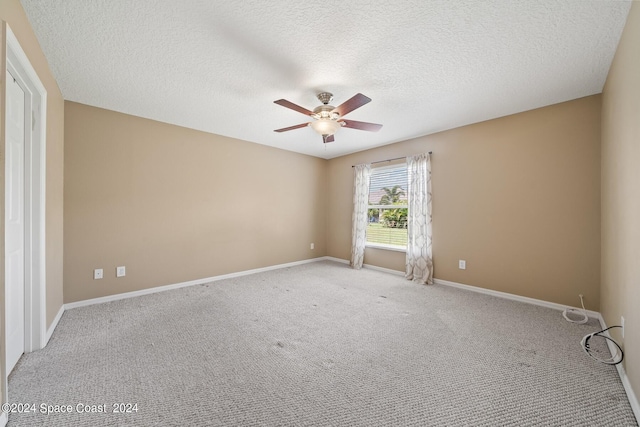 spare room with a textured ceiling, ceiling fan, and light carpet