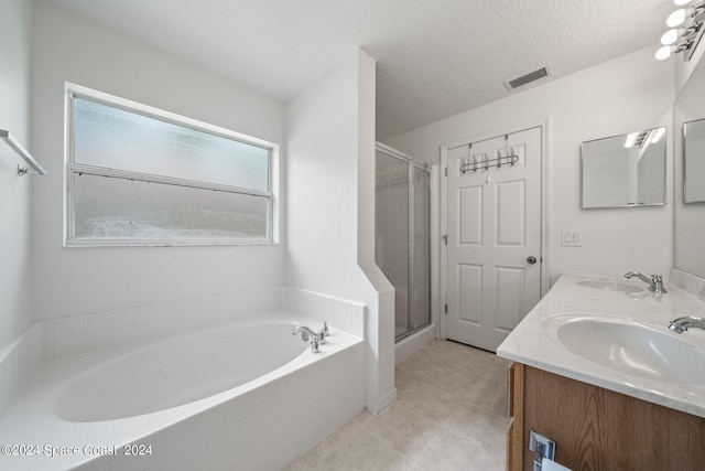 bathroom with a textured ceiling, vanity, tile patterned flooring, and shower with separate bathtub