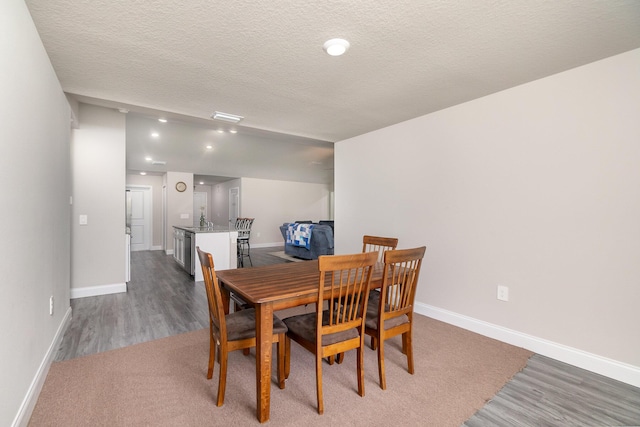 dining space with dark hardwood / wood-style flooring and a textured ceiling