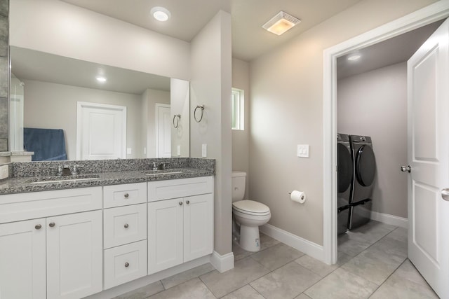 bathroom with vanity, toilet, tile patterned flooring, and washer and dryer