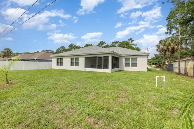 rear view of property featuring a yard and a sunroom