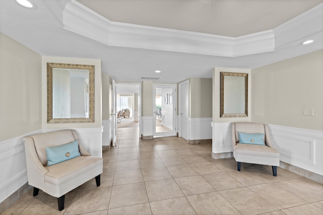 living area with light tile patterned floors and crown molding