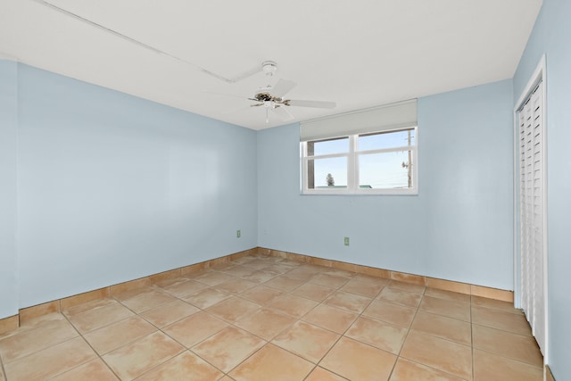 empty room with ceiling fan and light tile patterned flooring