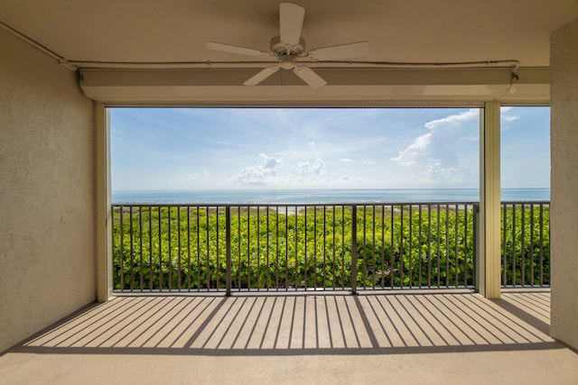 balcony with ceiling fan and a water view