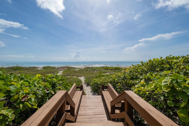 view of property's community featuring a water view and a beach view