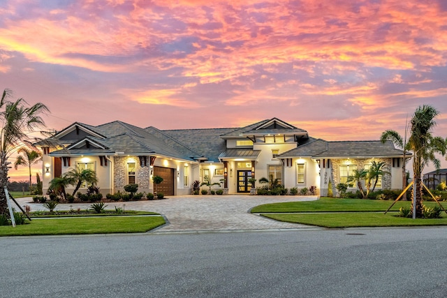 prairie-style house featuring a garage, french doors, and a lawn