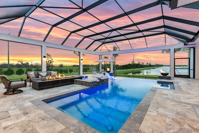 pool at dusk featuring an outdoor hangout area, a patio, and glass enclosure