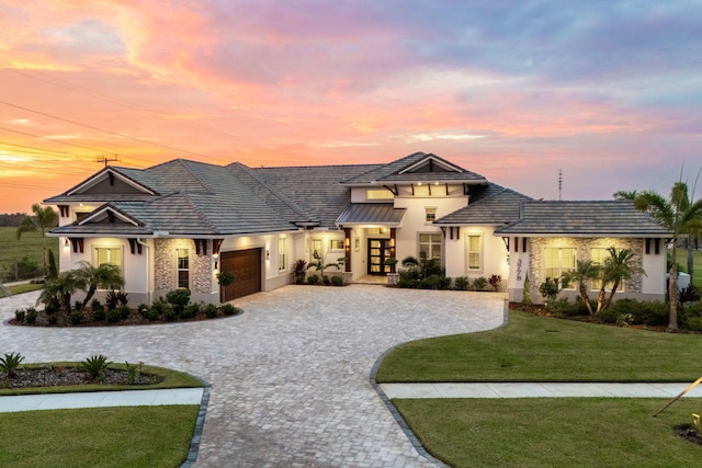 view of front of property with a yard and a garage