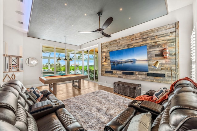 living room featuring wood-type flooring, a textured ceiling, billiards, and ceiling fan