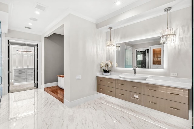 bathroom with a notable chandelier, crown molding, tile patterned floors, and vanity