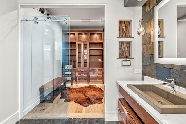 bathroom with tasteful backsplash, hardwood / wood-style flooring, and vanity