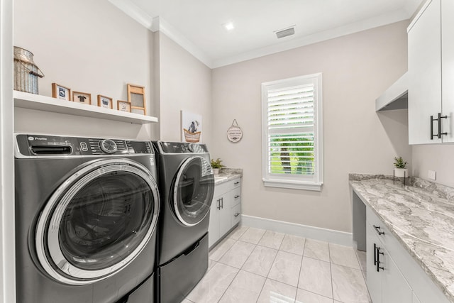 washroom with light tile patterned floors, cabinets, washing machine and clothes dryer, and ornamental molding