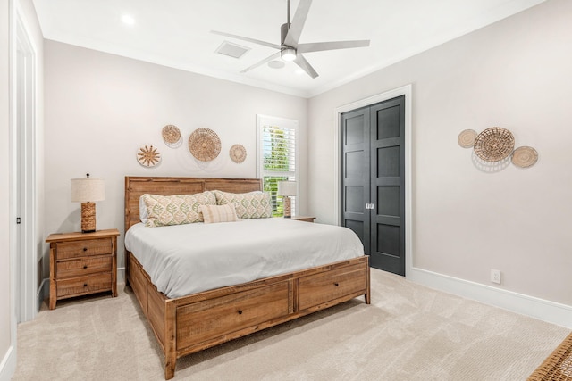 carpeted bedroom with ceiling fan, ornamental molding, and a closet