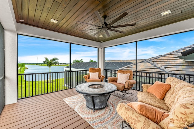 sunroom / solarium with a water view, wood ceiling, and ceiling fan