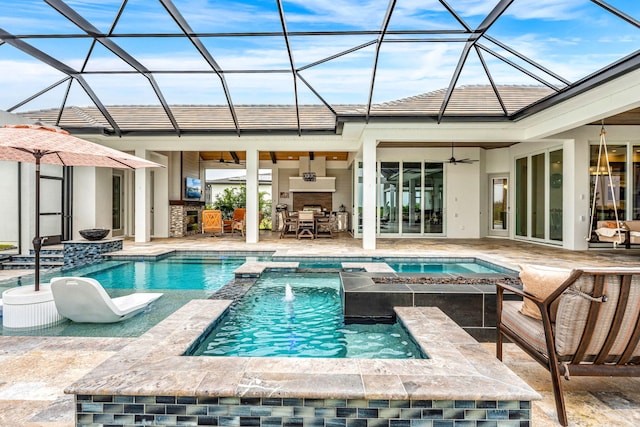 view of pool with a lanai, pool water feature, ceiling fan, an in ground hot tub, and a patio