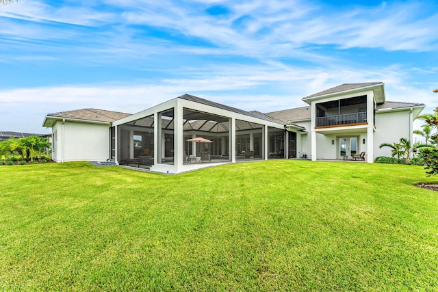 rear view of house featuring french doors, a yard, and glass enclosure