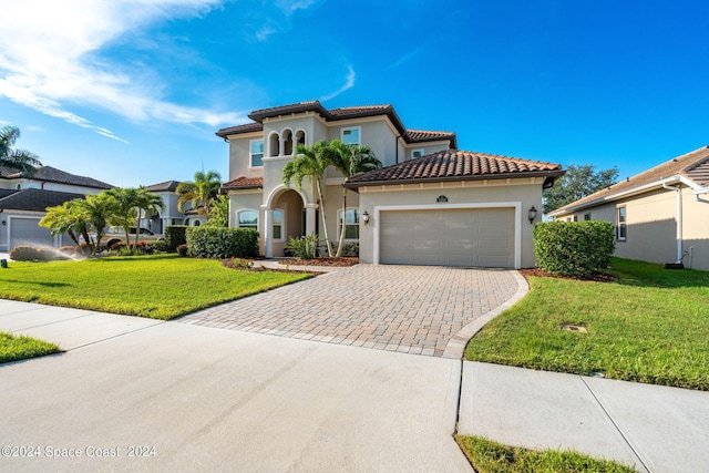 mediterranean / spanish house featuring a front yard and a garage