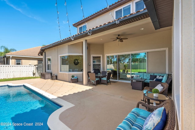 view of pool with an outdoor living space, ceiling fan, and a patio area