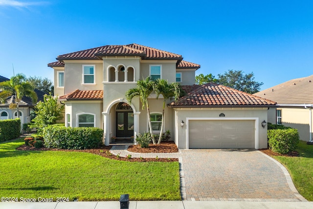 mediterranean / spanish-style home featuring a garage and a front yard