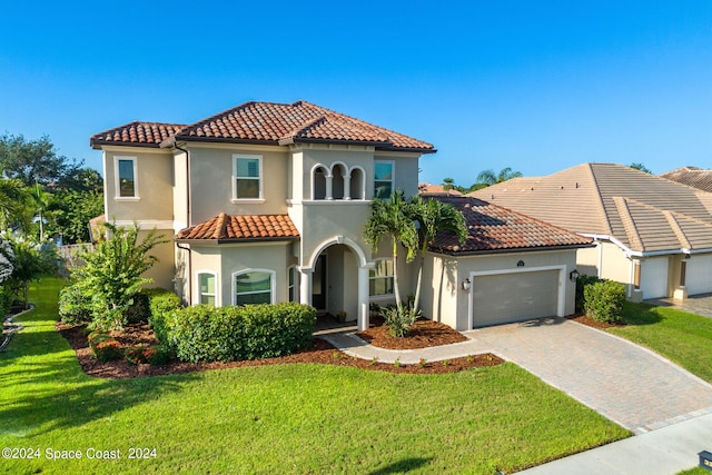 mediterranean / spanish house with a front yard and a garage