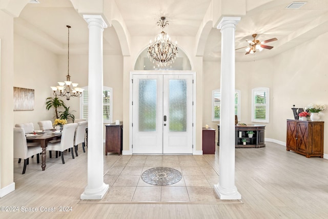 entrance foyer featuring light hardwood / wood-style flooring, a high ceiling, ceiling fan with notable chandelier, and french doors