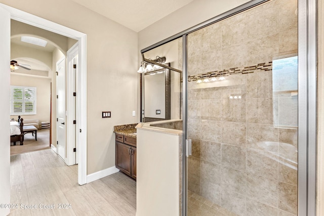 bathroom with an enclosed shower, vanity, ceiling fan, and hardwood / wood-style flooring