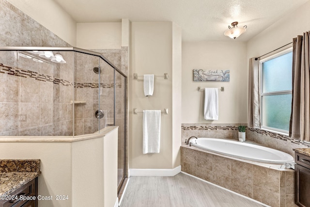 bathroom featuring vanity, shower with separate bathtub, a textured ceiling, and hardwood / wood-style flooring