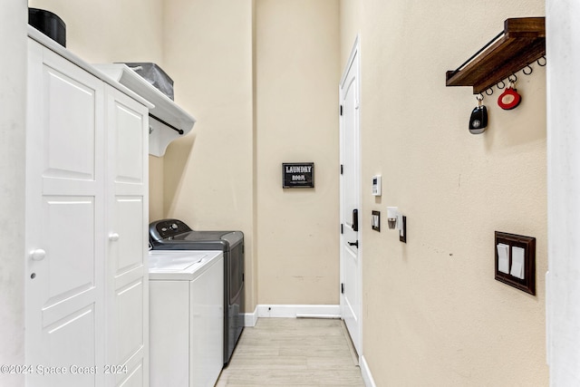 laundry area with washer and clothes dryer and light hardwood / wood-style flooring