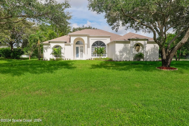 mediterranean / spanish home featuring a front lawn