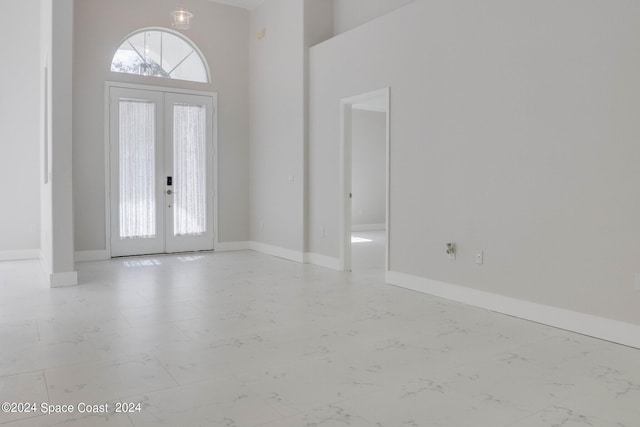 foyer entrance with french doors and a high ceiling