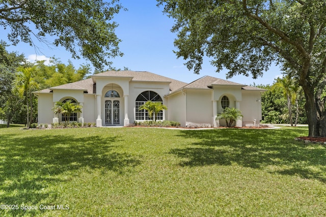 3520 Shady Run Rd, Melbourne, FL 32934 - mediterranean / spanish-style home with stucco siding, a front lawn, and roof with shingles