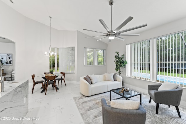3520 Shady Run Rd, Melbourne, FL 32934 - living room with baseboards, a chandelier, a ceiling fan, arched walkways, and light marble finish floors