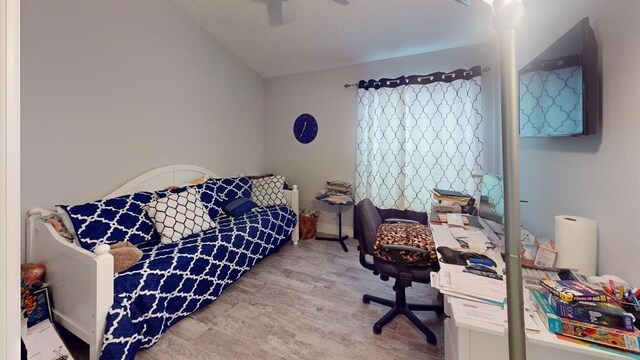 bedroom with vaulted ceiling, light wood-type flooring, and ceiling fan