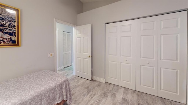 bedroom with light hardwood / wood-style floors and a closet