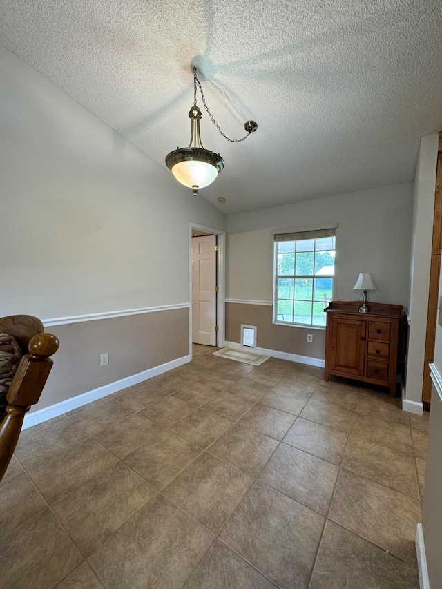 empty room with tile patterned flooring and a textured ceiling