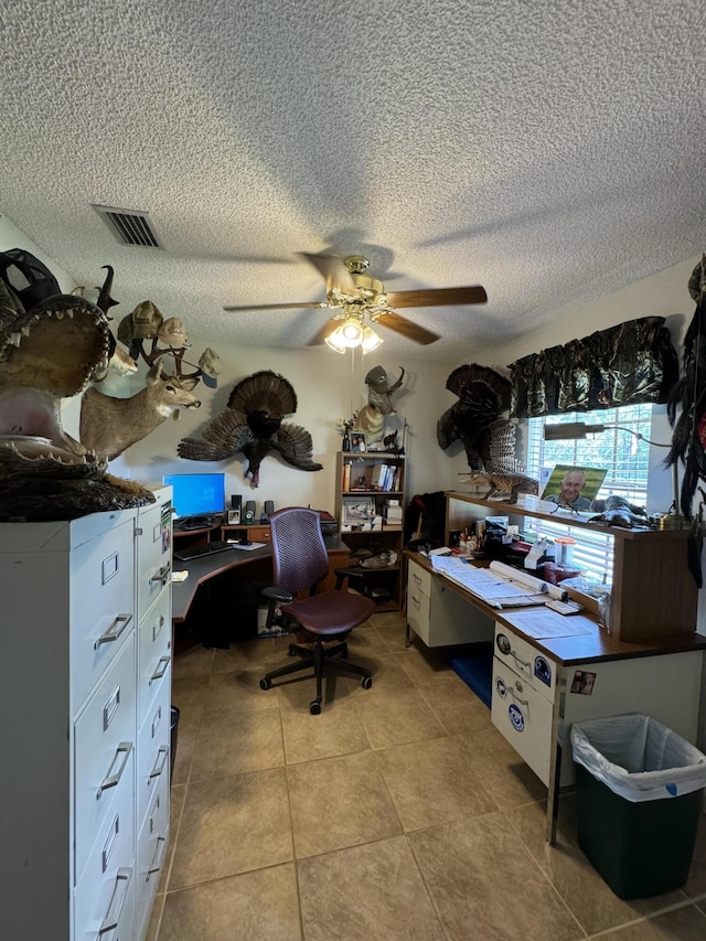 tiled office featuring ceiling fan and a textured ceiling