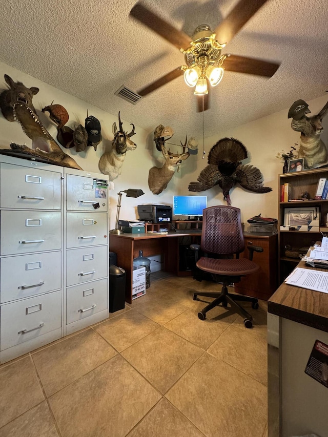 tiled office featuring a textured ceiling and ceiling fan