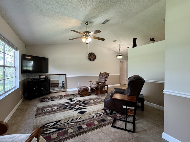 living room with ceiling fan, a textured ceiling, tile patterned floors, and lofted ceiling