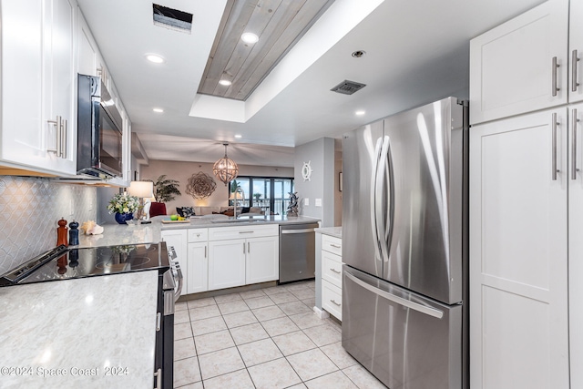 kitchen with stainless steel appliances, light tile patterned floors, sink, tasteful backsplash, and white cabinetry