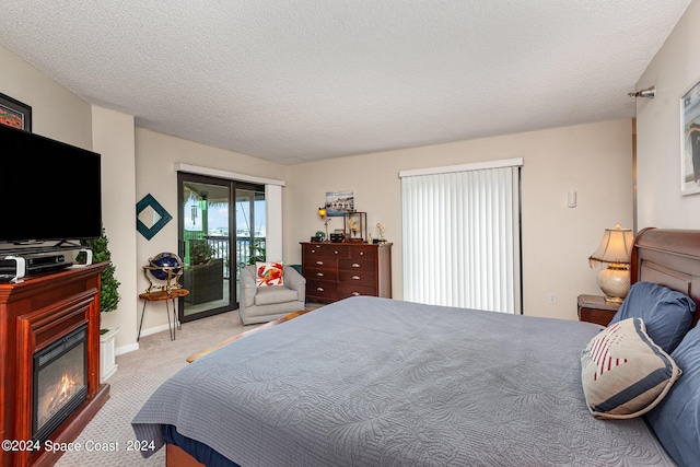 carpeted bedroom featuring access to exterior and a textured ceiling